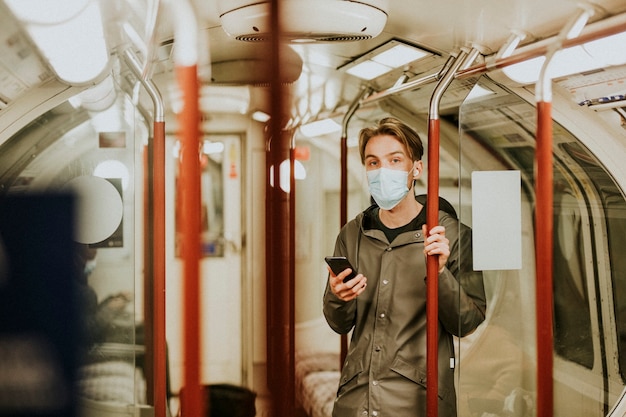 Hombre usando un teléfono en un tren en la nueva normalidad