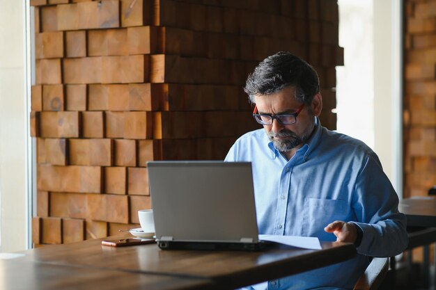 Foto hombre, utilizar, computador portatil, en, café, barra