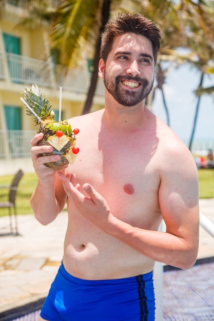 Hombre de vacaciones en risort bebiendo bebida dulce de piña.