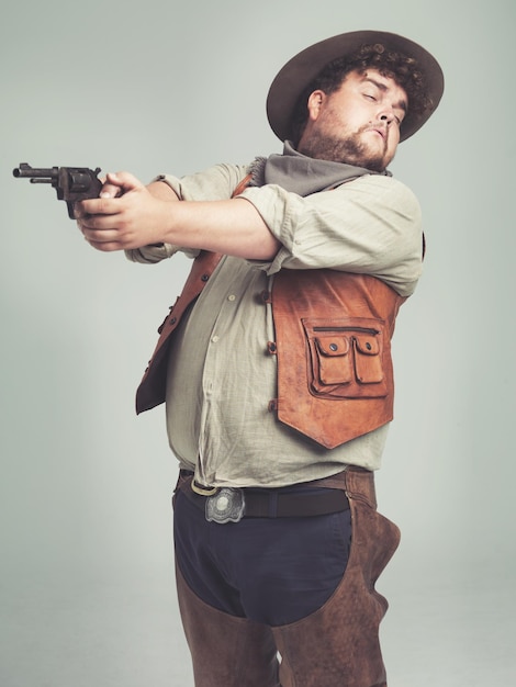Hombre vaquero y arma de tiro en el estudio arma y pistola con traje occidental aislado sobre fondo blanco tamaño criminal o persona divertida con revólver adivina apuntar o asustado con miedo en Texas