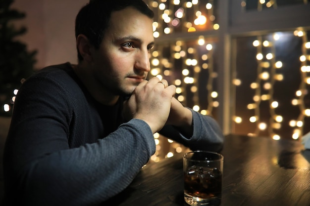 Hombre con vaso de whisky en el pub en la noche