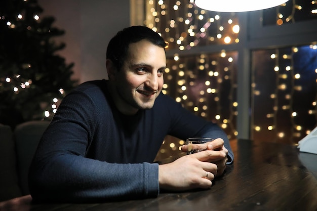 Hombre con vaso de whisky en el pub por la noche