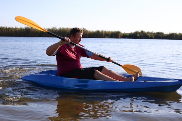 Un hombre en verano nada en el río en un kayak