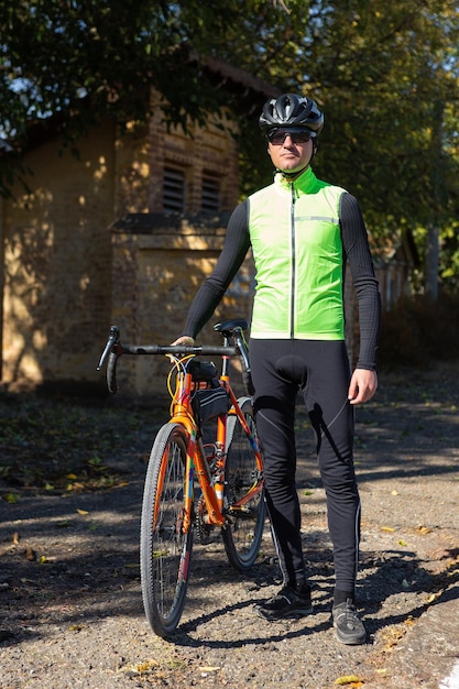 Un hombre vestido con una bicicleta en un día soleado de otoño Ciclista en un entorno urbano