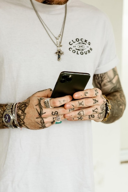 Un hombre vestido con una camisa blanca con colores de relojes en ella