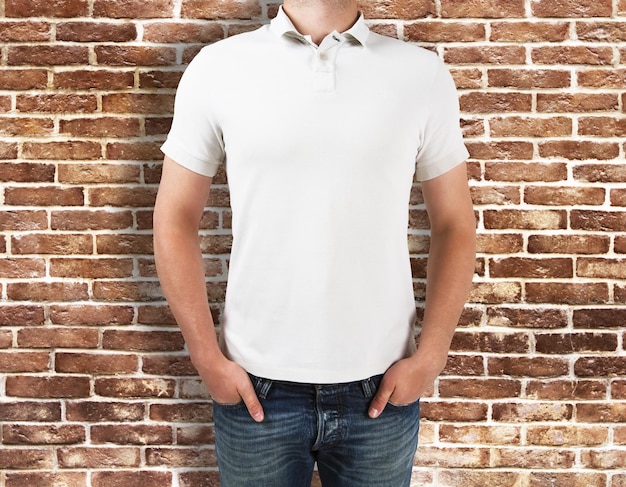 Foto hombre vestido con camisa blanca sobre fondo de ladrillo