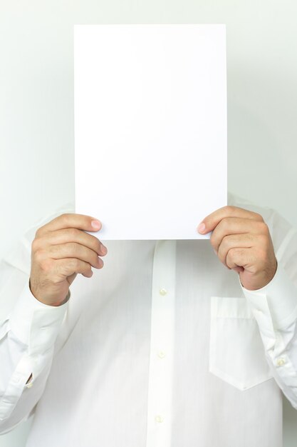 Foto hombre vestido con camisa sosteniendo una hoja en blanco