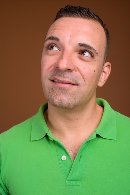 Foto hombre vestido con camisa verde sobre marrón