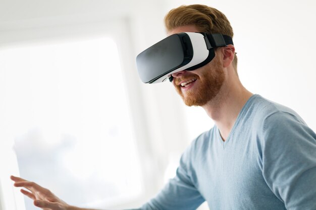 Hombre vestido con casco de realidad virtual en casa probando una nueva experiencia