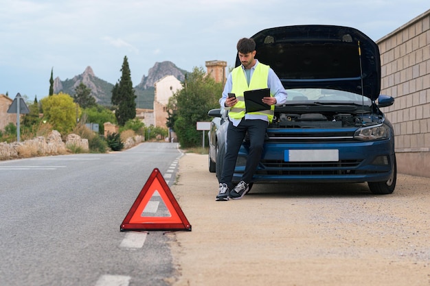 Hombre vestido con un chaleco reflectante mirando un informe de un accidente automovilístico