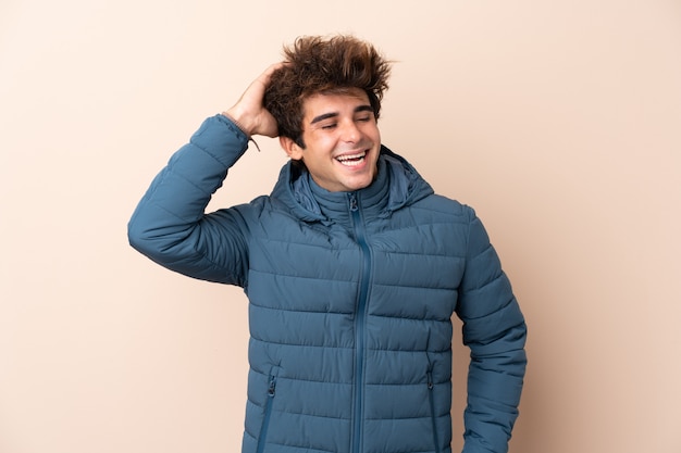 Hombre vestido con chaqueta de invierno sobre pared aislada