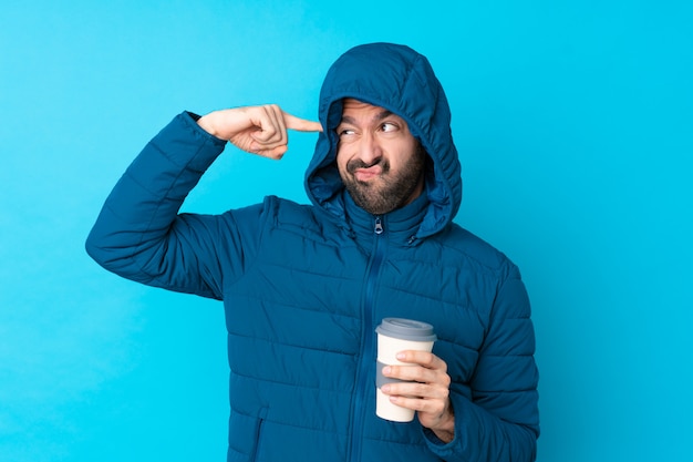 Hombre vestido con chaqueta de invierno sobre pared aislada