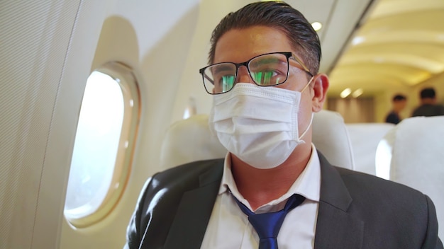 Hombre vestido con mascarilla en un avión