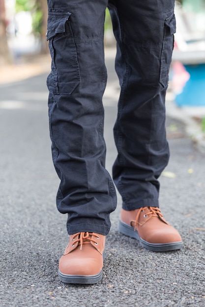 Foto hombre vestido con pantalón cargo negro y de pie en el parque natural