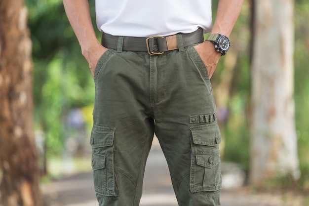 Foto hombre vestido con pantalones de carga de pie en el parque natural