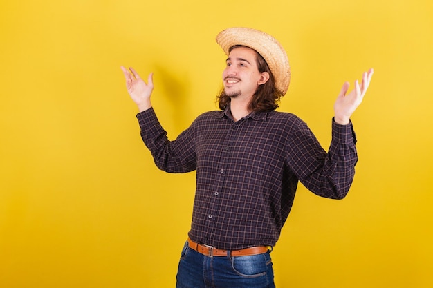 Foto hombre vestido con ropa típica de fiesta junina feliz mirando al cielo y dando gracias sentimiento de gratitud