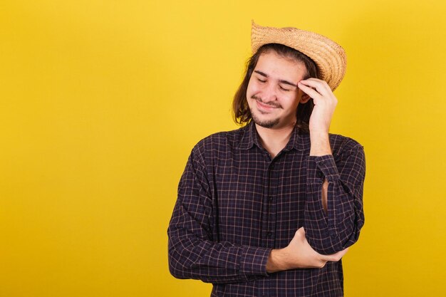 Foto hombre vestido con ropa típica de fiesta junina mano en la cabeza con dolor dolor de cabeza