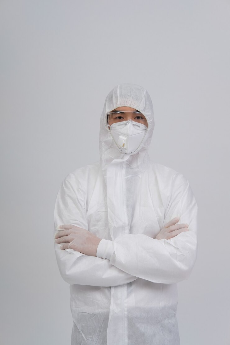 Hombre vestido con uniforme biológico protector, mascarilla y guantes