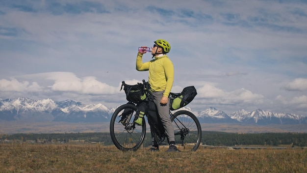 El hombre viaja en cicloturismo por terrenos mixtos con bikepacking El viajero que viaja con bolsas para bicicletas Turismo deportivo bikepacking