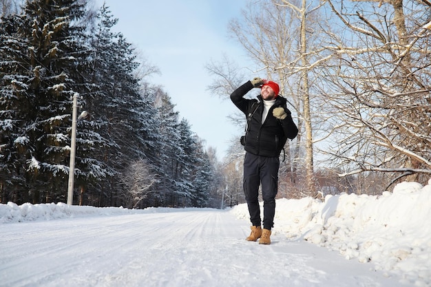 Un hombre viaja con mochila. Caminata de invierno en el bosque. Turista en un paseo en invierno en el parque.