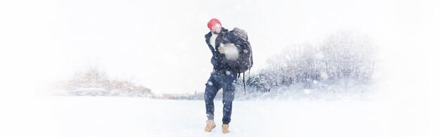 Un hombre viaja con una mochila caminata de invierno en el bosque turístico en un paseo en el invierno en el parque