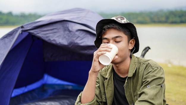 Hombre viajero beber café en el campamento