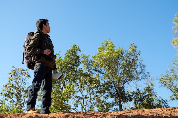 Hombre viajero con cámara fotográfica y mochila de excursión al aire libre Estilo de vida de viaje y concepto de aventura.