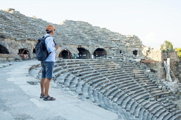 Hombre viajero explora el antiguo anfiteatro en la antigua ciudad de Turquía. Vacaciones de verano.