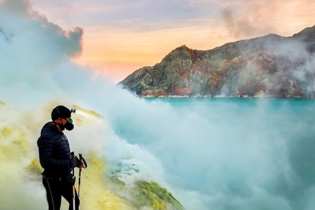 Hombre viajero con una máscara protectora en el cráter del peligroso volcán activo Ijen Indonesia