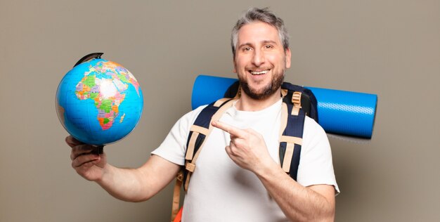 Hombre viajero de mediana edad con un mapa del mundo