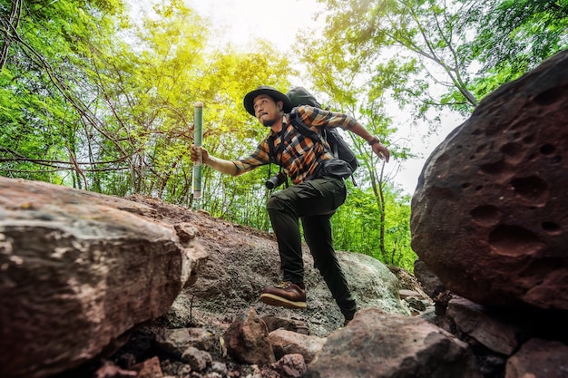 Hombre viajero con mochila corriendo en el bosque