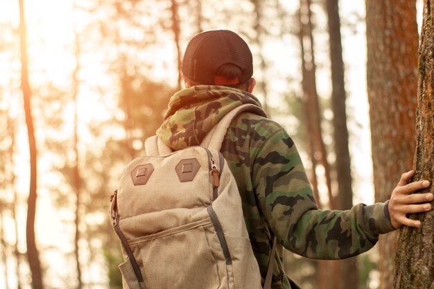 Hombre viajero con mochila de pie cerca de la selva tropical