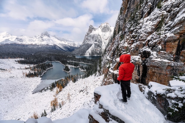 Hombre viajero senderismo en roca en invierno en la meseta de Opabin en el parque nacional Yoho