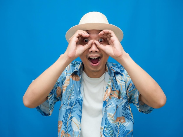 El hombre viajero usa un círculo de mano con sombrero en el fondo azul de sus ojos