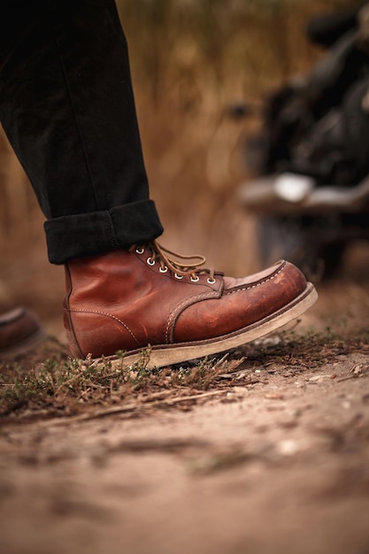 Foto hombre con viejas botas marrones. fondo de pantalla. zapatos de moto