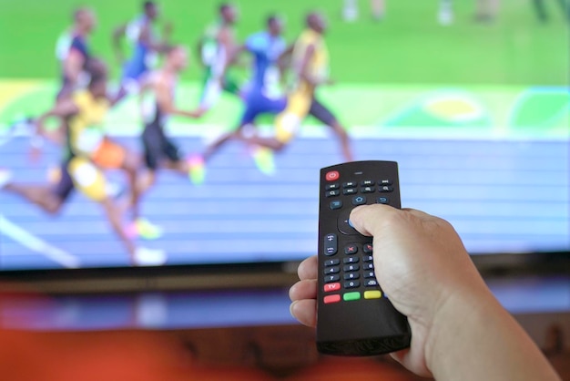 Hombre viendo deportes de atletismo en la televisión