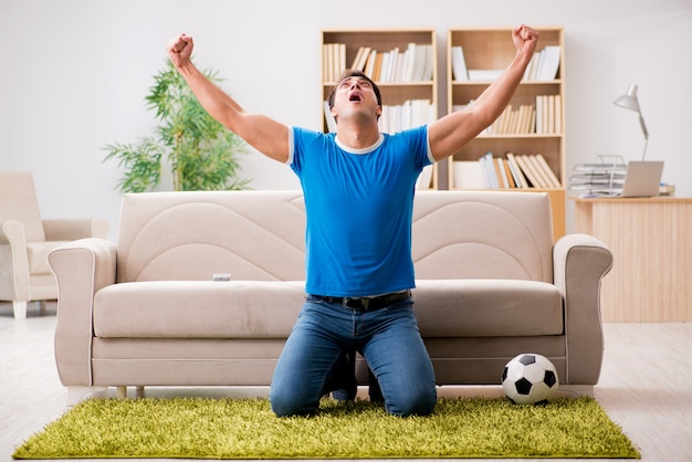 Hombre viendo futbol en casa