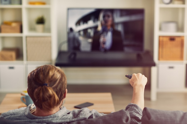 Hombre viendo televisión de pantalla grande