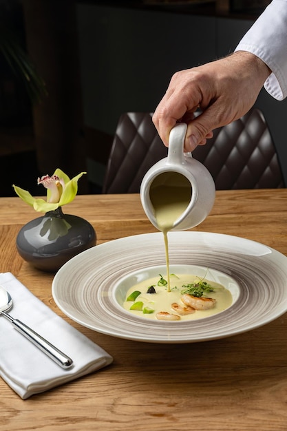 Un hombre vierte una sopa de un plato de sopa.