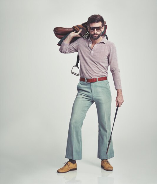 Foto hombre vintage y silla de montar con cultivo en el estudio para ocio y confianza con gafas de sol persona ecuestre y ropa hipster de estilo de los años 70 o traje retro para la moda en fondo blanco