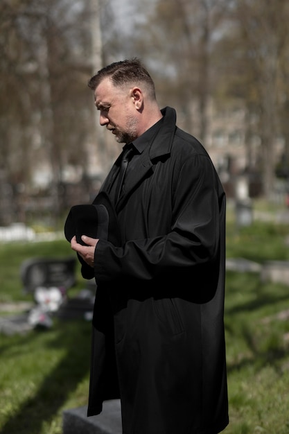 Foto hombre visitando el cementerio