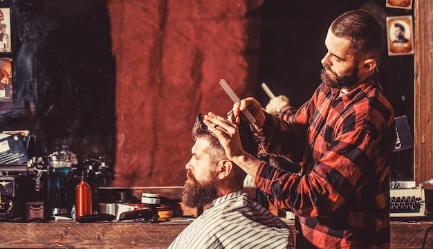 Hombre visitando estilista en peluquería. Hombre barbudo en peluquería. Trabaja en la peluquería. Estilista de hombre.