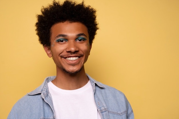 Hombre de vista frontal con maquillaje gráfico en los ojos