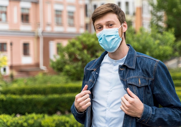 Foto hombre de vista frontal con una mascarilla exterior con espacio de copia