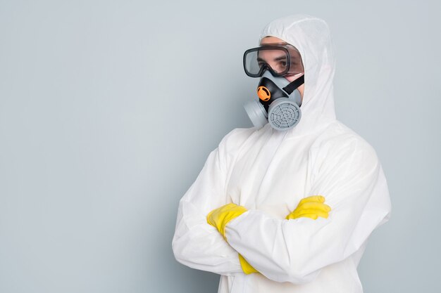 El hombre viste un traje de protección blanco y una máscara.