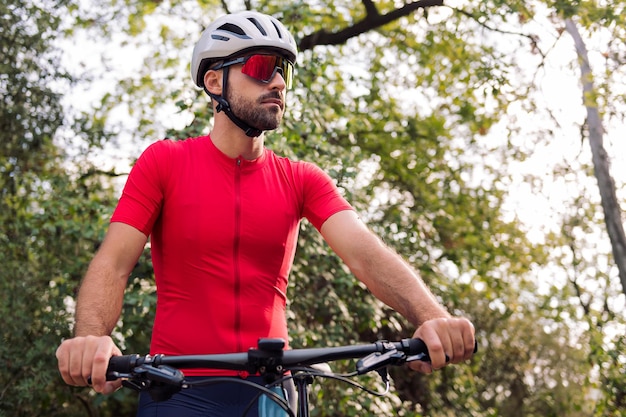 Hombre vistiéndose junto a su furgoneta para ir en bicicleta