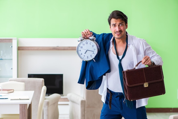 Foto hombre vistiéndose y llegando tarde al trabajo.