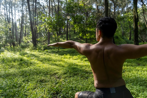 Hombre visto de cerca sin camisa haciendo estiramientos en ejercicio de colchoneta de yoga latinoamérica