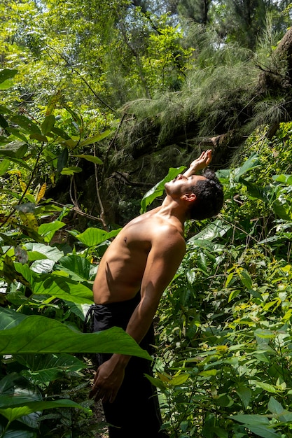 Hombre visto de cerca sin camisa haciendo estiramientos en ejercicio de colchoneta de yoga latinoamérica