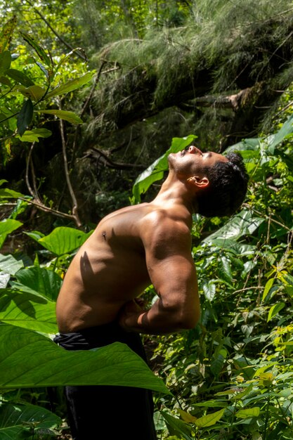 Hombre visto de cerca sin camisa haciendo estiramientos en ejercicio de colchoneta de yoga latinoamérica